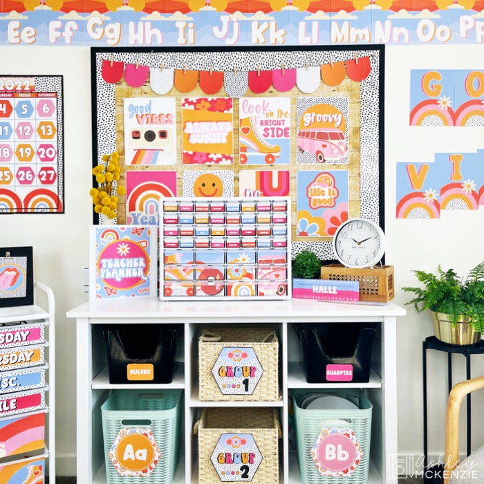 A classroom decorated with a bright and cheerful retro theme featuring pink, orange, red, and purple.