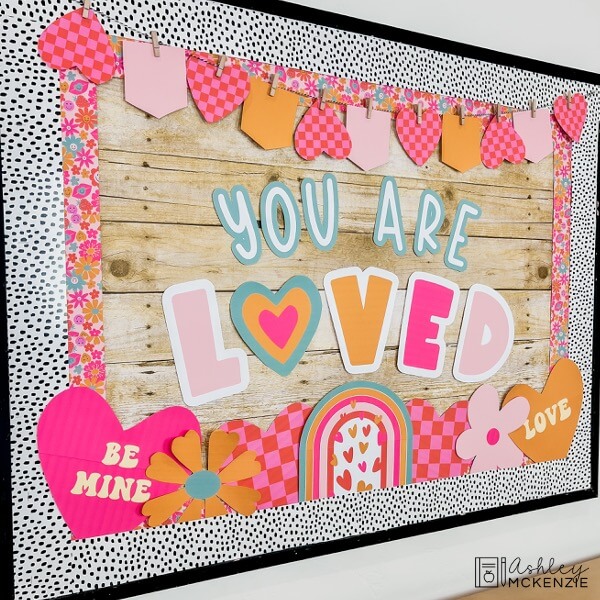 The saying "You are loved" is displayed on a Valentine's Day themed bulletin board.