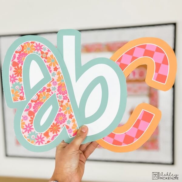 Lowercase letters a, b, and c are held up in a fun Valentine's Day themed design. 