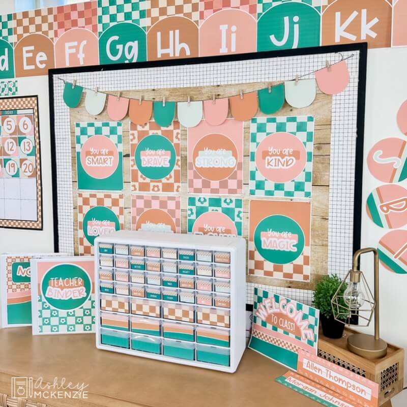 A classroom display featuring a modern checkered theme with a teacher toolbox centered beneath a bulletin board with positive mindset classroom posters.