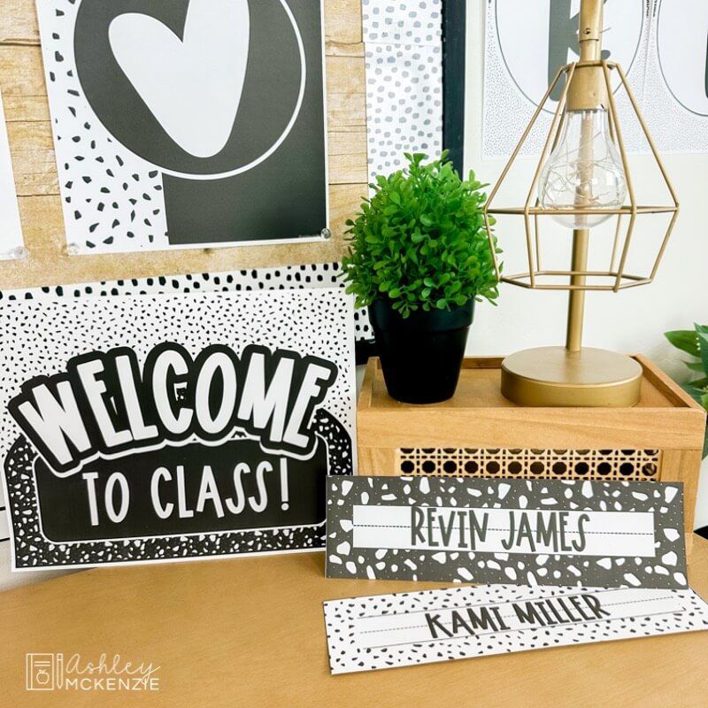 A "Welcome to Class" sign next to two student name tags in a black  and white terrazzo design