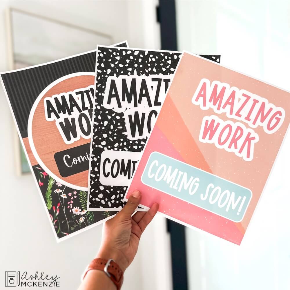 3 different designs of "Amazing Work Coming Soon" posters are held up featuring a pastel design, a black and white terrazzo design, and a wildflowers theme.