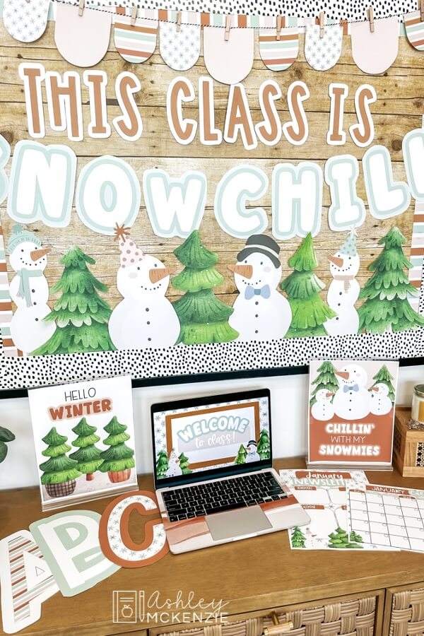 Winter classroom decor is displayed including a bulletin board decorated with snowmen and evergreen trees and the saying "This class is snow chill" and more matching winter decor