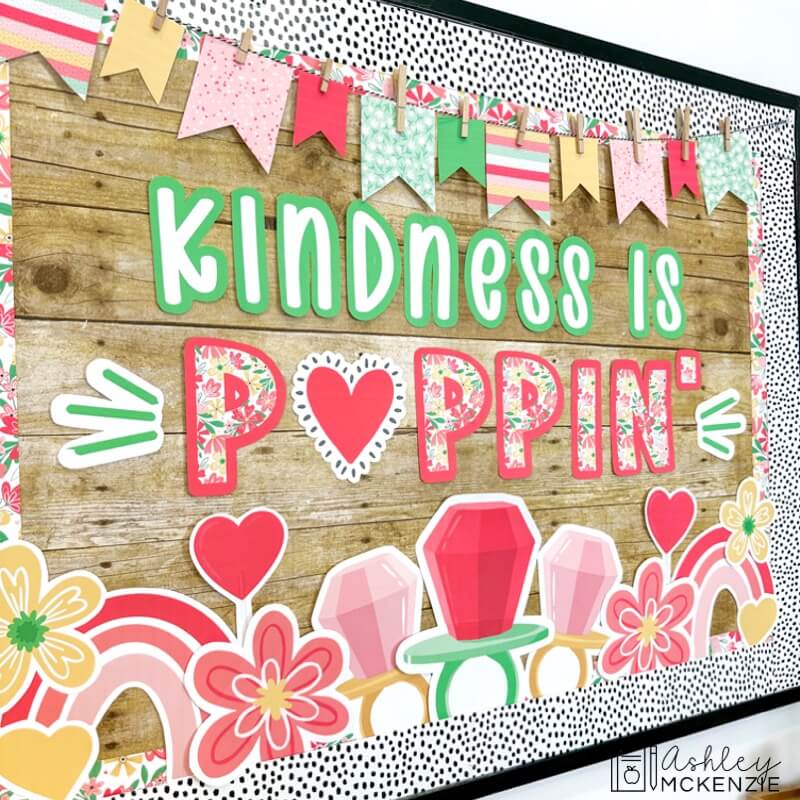 A classroom bulletin board decorated with a Valentine's Day theme with the saying "Kindness is Poppin'"