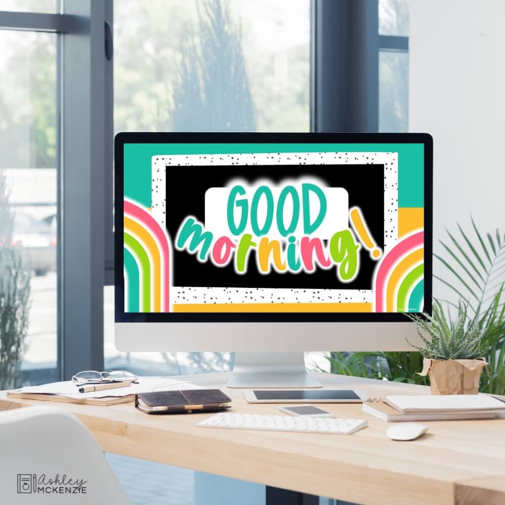 A classroom computer displaying a bright neon themed design that says "good morning"